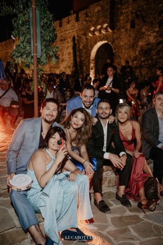 Cake cutting ceremony at Castello di Rocca Cilento with panoramic night view.