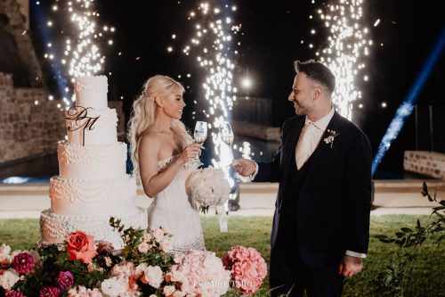Cake cutting ceremony at Castello di Rocca Cilento with panoramic night view.