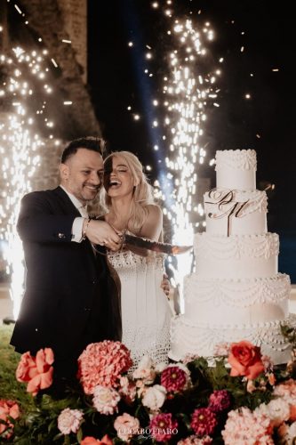 Cake cutting ceremony at Castello di Rocca Cilento with panoramic night view.
